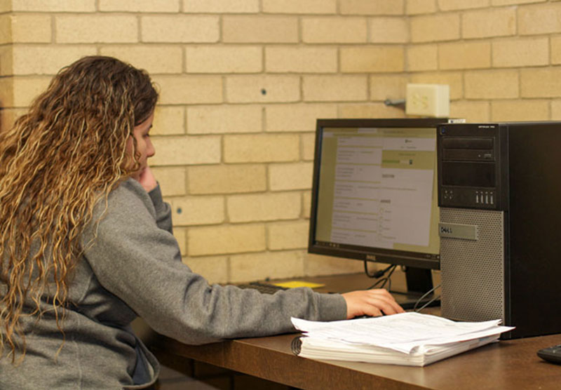 female student doing classwork on a desktop computer