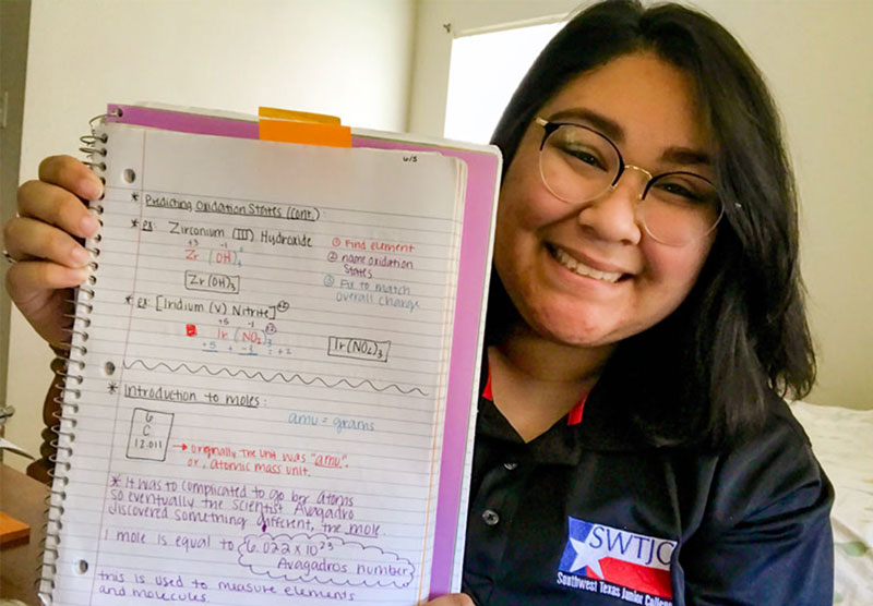female student holding a notebook with written notes
