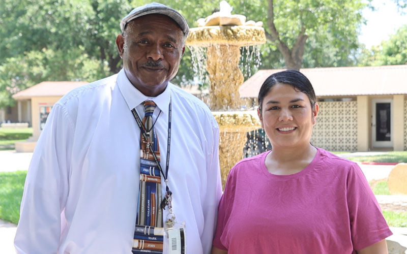GED graduate Eunice Garza poses with AEL instructor Daryl Colvin at the Fountain Courtyard of the Uvalde campus.