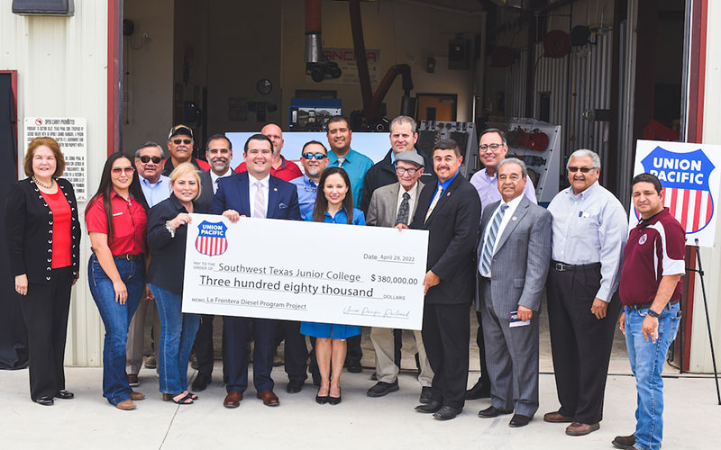 SWTJC and Union Pacific representatives pose for a photo outside of the SWTJC Diesel Shop on the Eagle Pass campus. Individuals in the center of the photo hold a cardboard check made out to SWTJC in the amount of $380,000.
